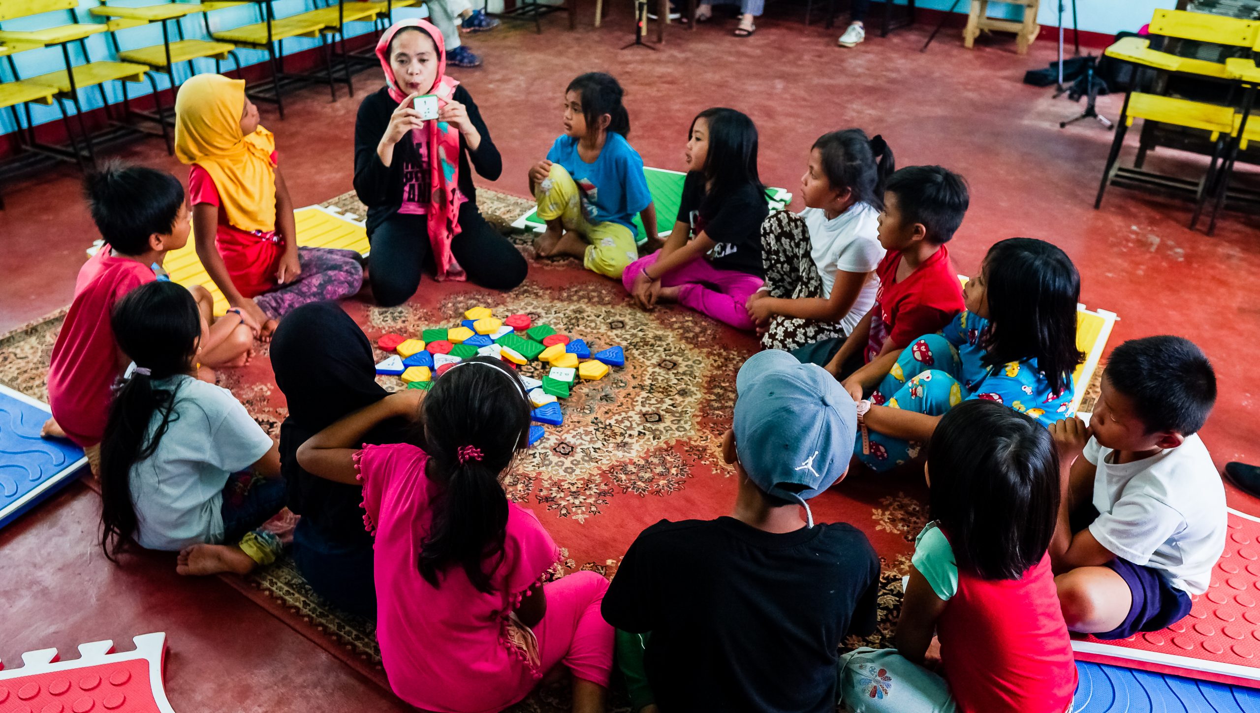 a teacher is teaching a group of young children how to play reach and match