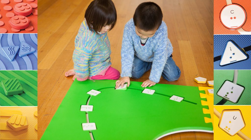 two children are playing on the reach & match mats.